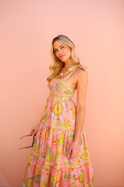Woman wearing a colorful dress with a pink background